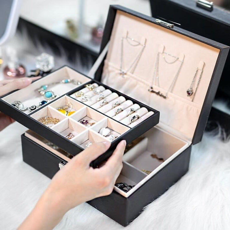 Black double-layer jewelry storage box open with cushioned compartments for necklaces and rings