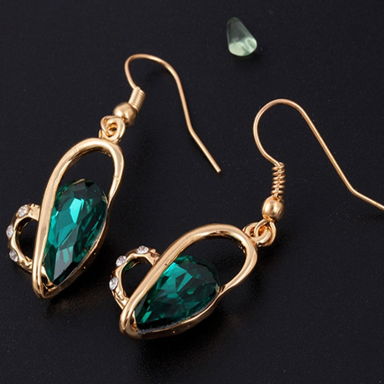 Gold-tone heart crystal drop earrings with green faceted stones, close-up