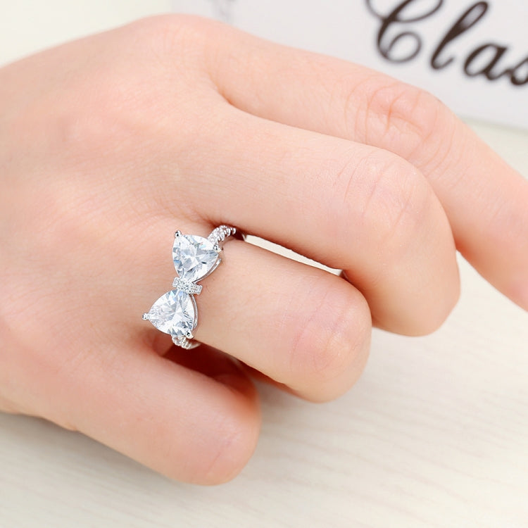 Silver bowknot zircon ring on hand, featuring three clear marquise stones