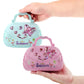 Hand holding mint and pink handbag-style music jewelry boxes with heart graphics