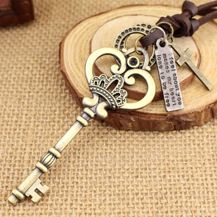 Close-up crown key pendant with heart charm, engraved tag, and small key charm