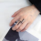 Black geometric open finger ring on hand, two bar accents over open band
