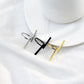 Geometric open finger rings in black, silver, and gold colors on white dish