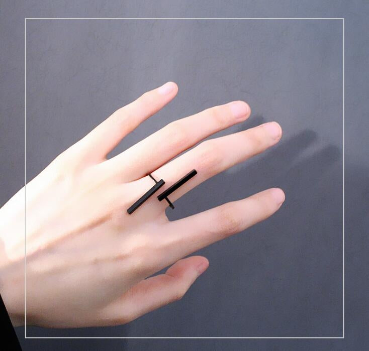 Black geometric open finger ring on hand with two bar accents and open band