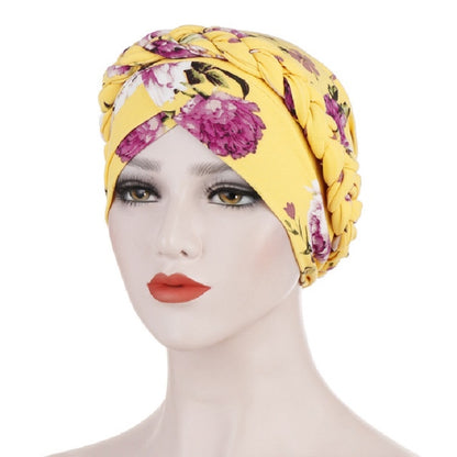 Women’s printed yellow turban hat with floral accents, short pullover style.