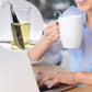 Pipe-shaped stainless steel tea infuser in a cup while held beside a mug