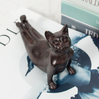 Dark brown yoga cat figurine, seated with arms raised