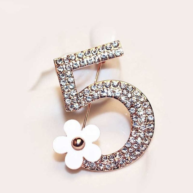 Number 5 rhinestone brooch with white flower accent, rose-gold tone frame