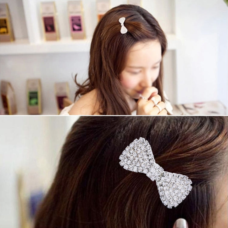 Silver crystal rhinestone bow hairpin on dark hair, bow centered