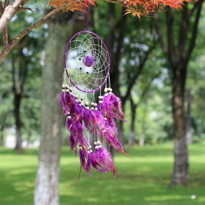 Purple dreamcatcher ornament with round web hoop, beads, and hanging feather strands.