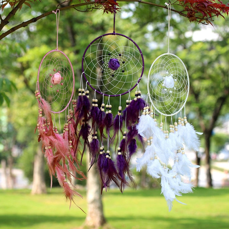 Three dreamcatcher ornaments in purple, green, and white with beaded chains and feathers.