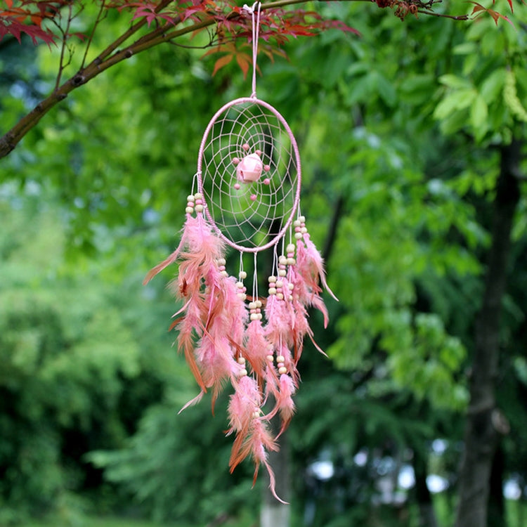 Pink dreamcatcher ornament with round web hoop, beaded drops, and feather fringe.