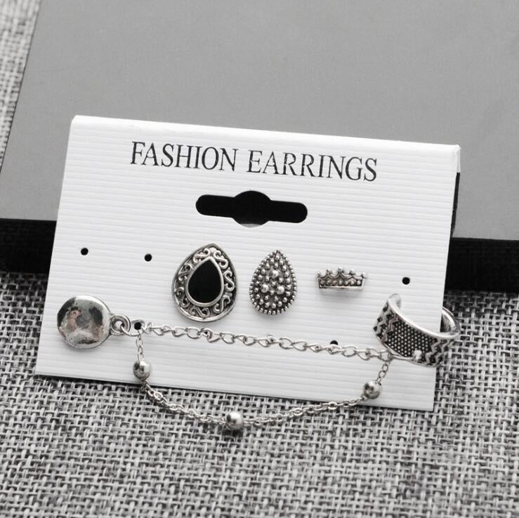 Assorted silver-tone fashion earrings set on card: oval stud, textured bead, crown