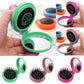 Hand-held green folding pocket hair brush with open round spiked pad