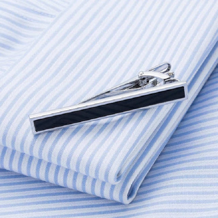 Black tie clip on a blue striped dress shirt collar