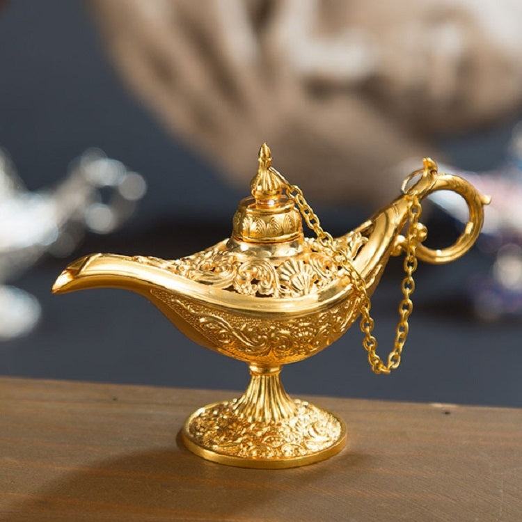 Gold metal Aladdin-style wish lamp with ornate base and chained handle