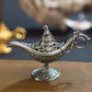 Silver metal Aladdin-style wish lamp with embossed details and hanging chain
