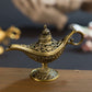 Bronze-gold metal wish lamp with ornate carvings and curled handle