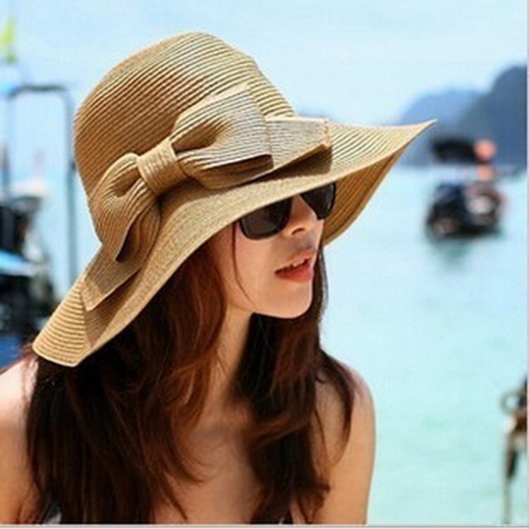 Girls wide-brim straw sun hat with bow, light tan; sunglasses visible.