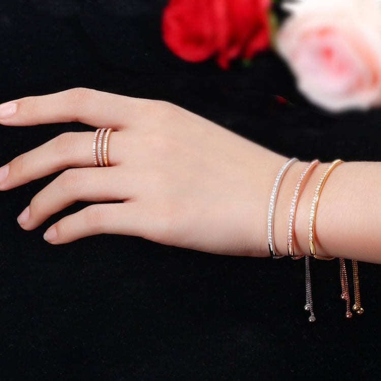 Adjustable gold zircon curved bracelet with dangling charms on wrist