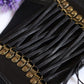 Close-up of black lace-up elastic cords with gold-tone metal eyelet details
