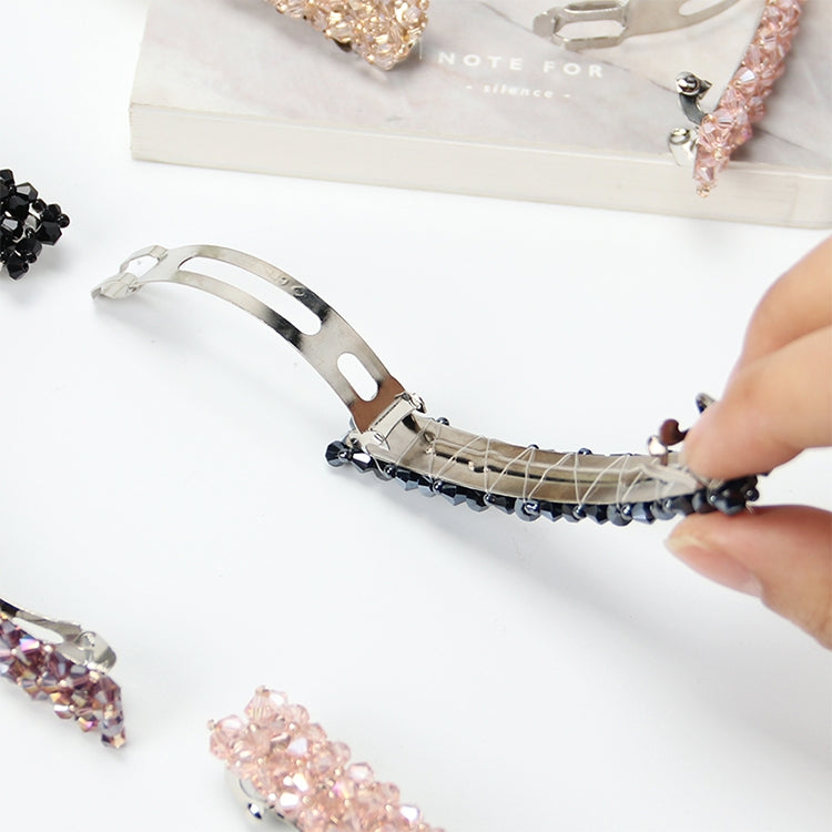 Pink rhinestone elastic hair clip with silver metal base, shown being clipped