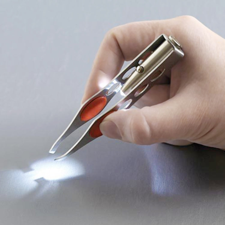 LED eyebrow clip tweezers in hand, stainless steel tool with red grips and light
