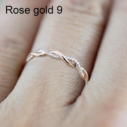 Rose gold twist cubic zirconia ring on finger, oval stones in curved design