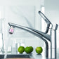 Tap water purifier faucet attachment on chrome kitchen faucet, clear water flow