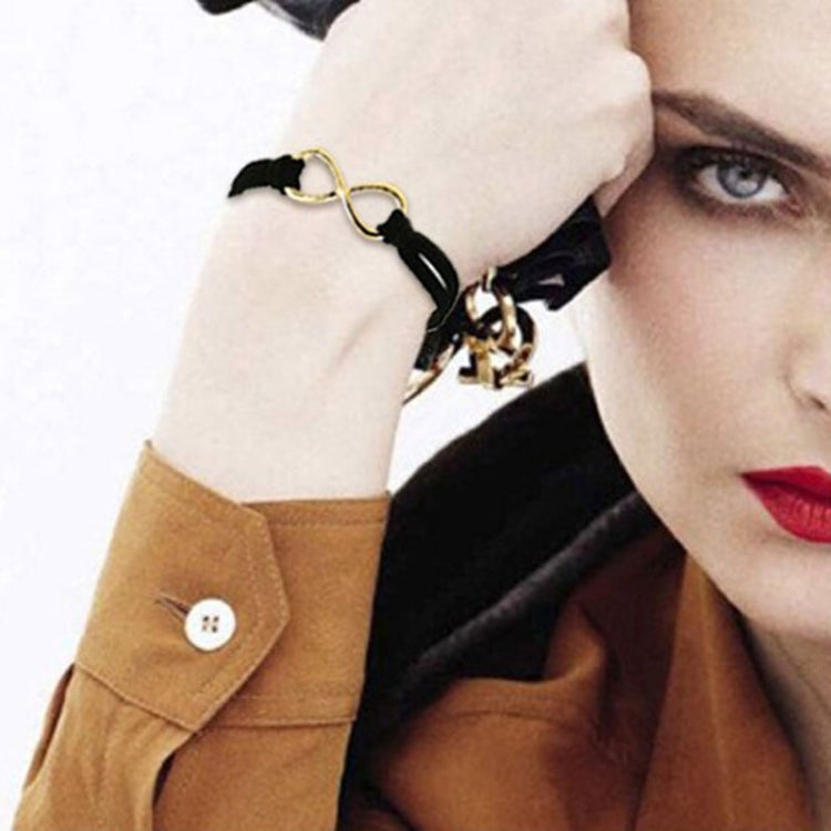 Black twine infinity symbol bracelet worn on wrist with gold-tone link detail