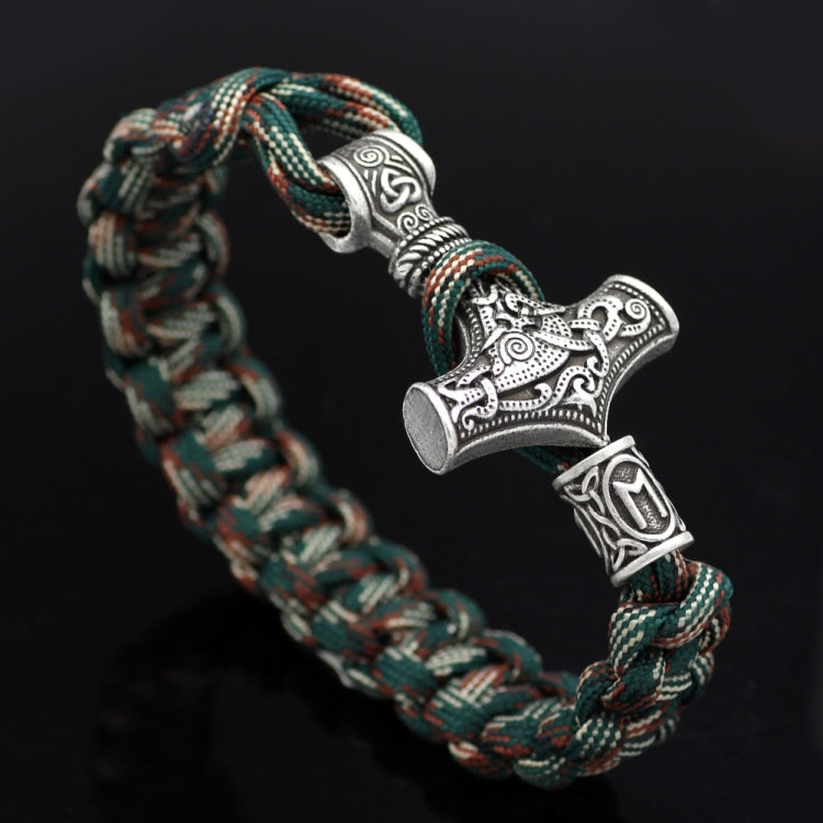 Braided rope bracelet with curved silver-tone Thor hammer charm near knot, teal mix