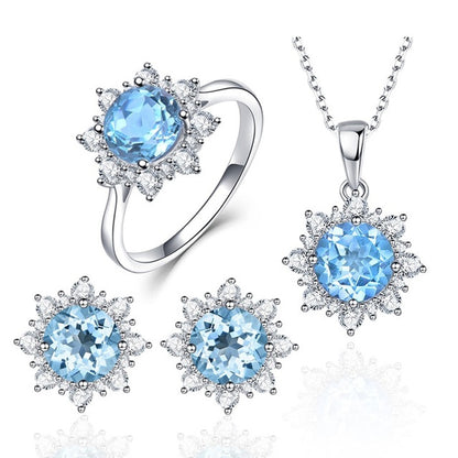 Silver jewelry set with bright blue oval gemstone ring, pendant necklace, and stud earrings.