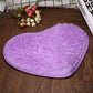 Purple heart-shaped bath mat with fluffy shag texture and non-slip edge binding.