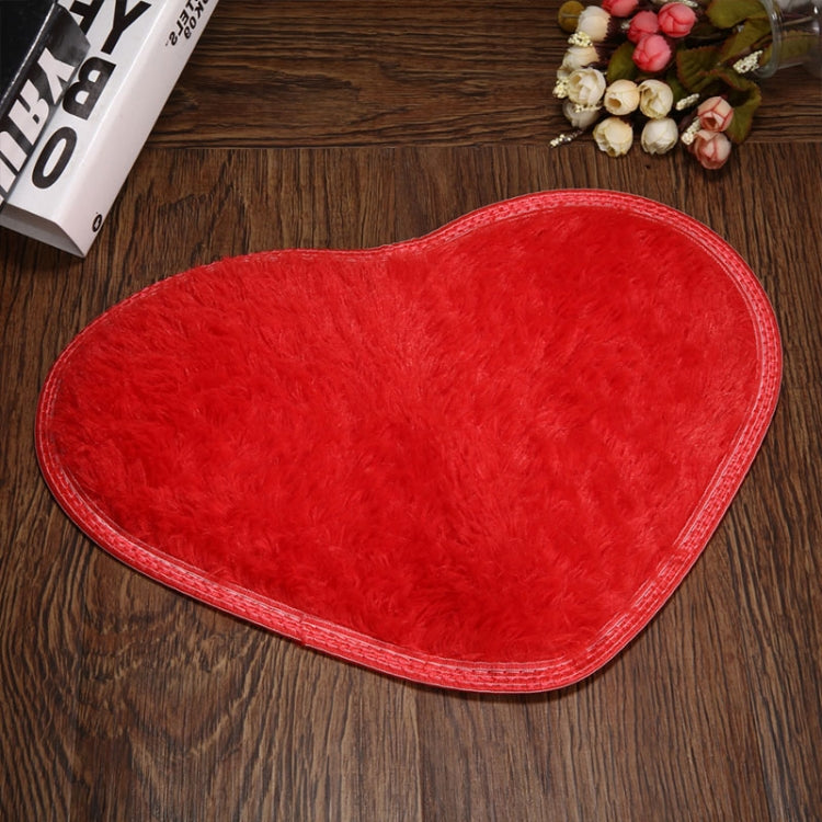 Red heart-shaped bath mat with plush shag pile and non-slip edge binding.