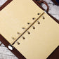 Spiral notebook journal with kraft paper pages and metal rings, on brown leather cover