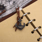 Close-up of pirate charm clasp and spiral rings on a kraft paper notebook journal