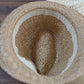 Children's khaki straw panama hat top view with round crown and dark striped band