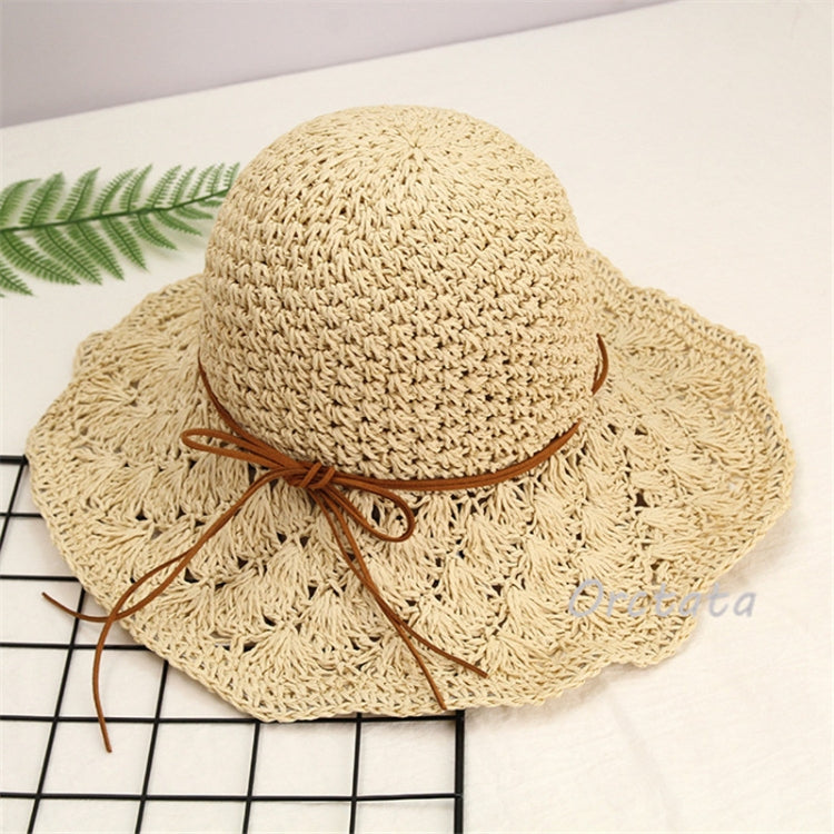 Beige wide-brim straw sun hat with knotted ribbon ties around the crown