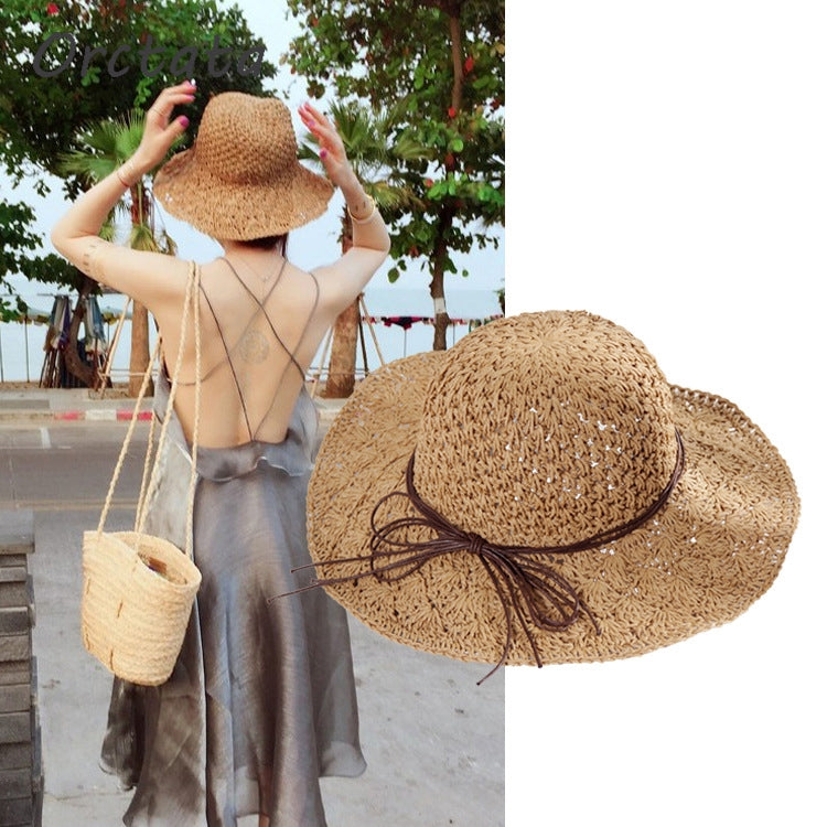 Beige straw sun hat worn with wide brim and brown ribbon bow ties