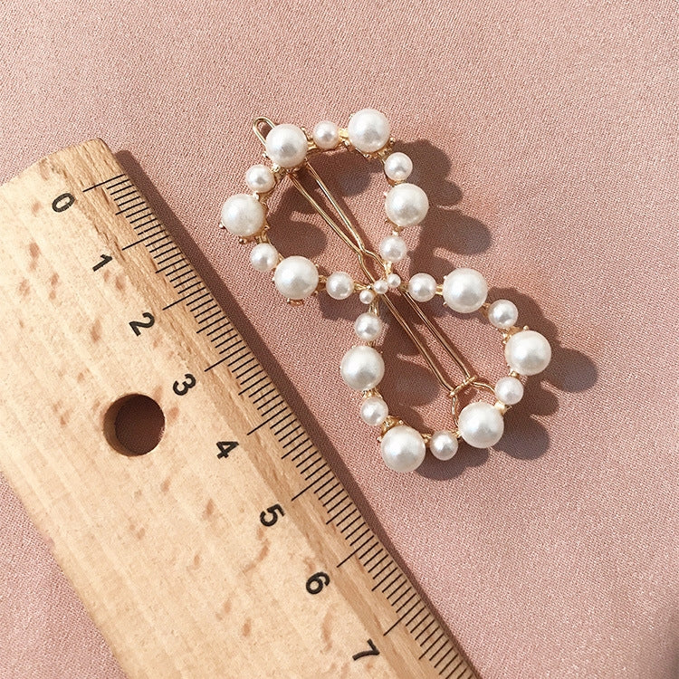 Pearl hairpin with circular cluster of white beads on gold-tone pins