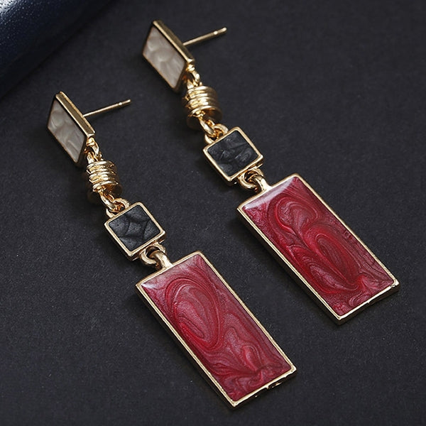 Long gold-tone drop earrings with red marbled rectangles and black squares between links