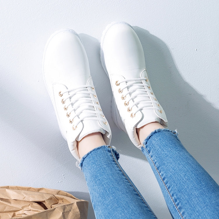 White lace-up boots on feet with blue jeans, front and side view
