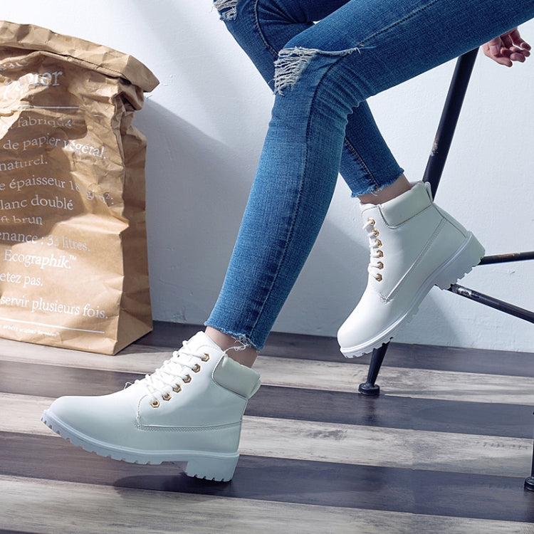 White lace-up boots with thick sole worn with blue jeans and low ankle socks