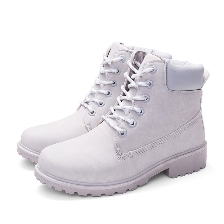 Pair of white lace-up warm ankle boots with padded collar and rugged tread sole