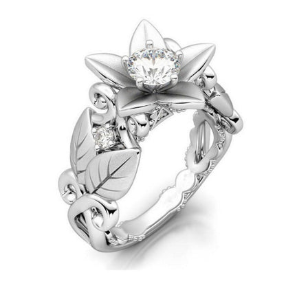 Silver flower wedding ring with central clear stone and diamond accents