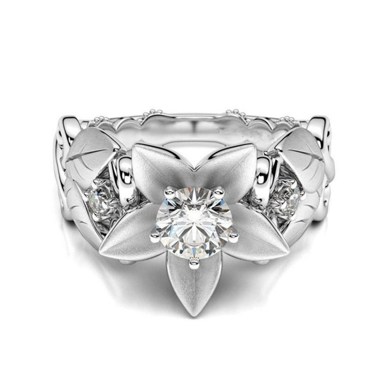 Wide silver wedding ring with central round stone and petal-like diamond settings