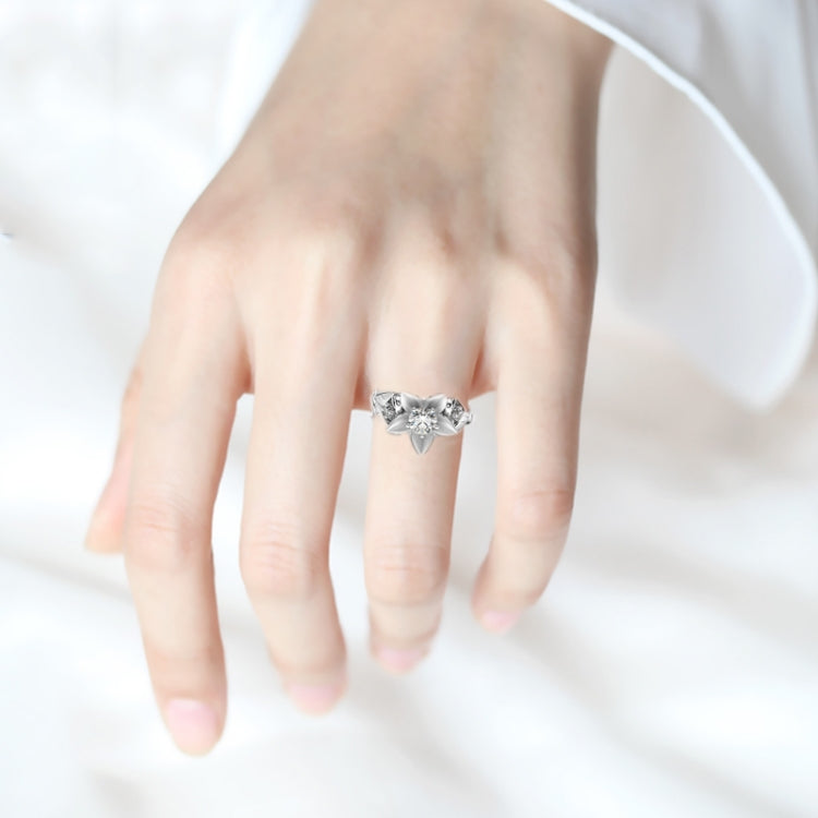 Silver wedding ring on hand with three-stone center and small side stones