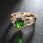Gold oval green center gemstone ring with round clear stone halo and side clusters
