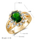 Gold ring with oval green center and round clear stones, halo setting