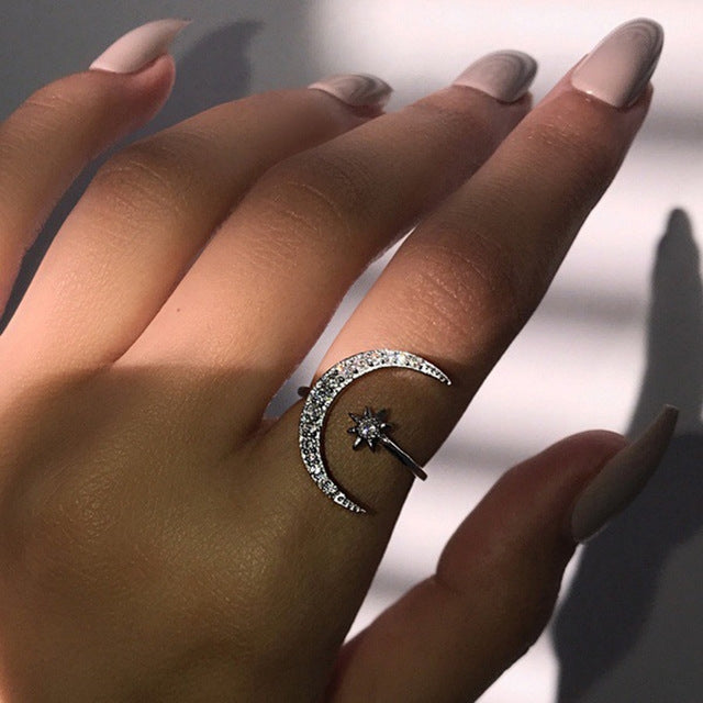 Crescent moon crystal ring with star top detail on finger, silver-tone sparkle band